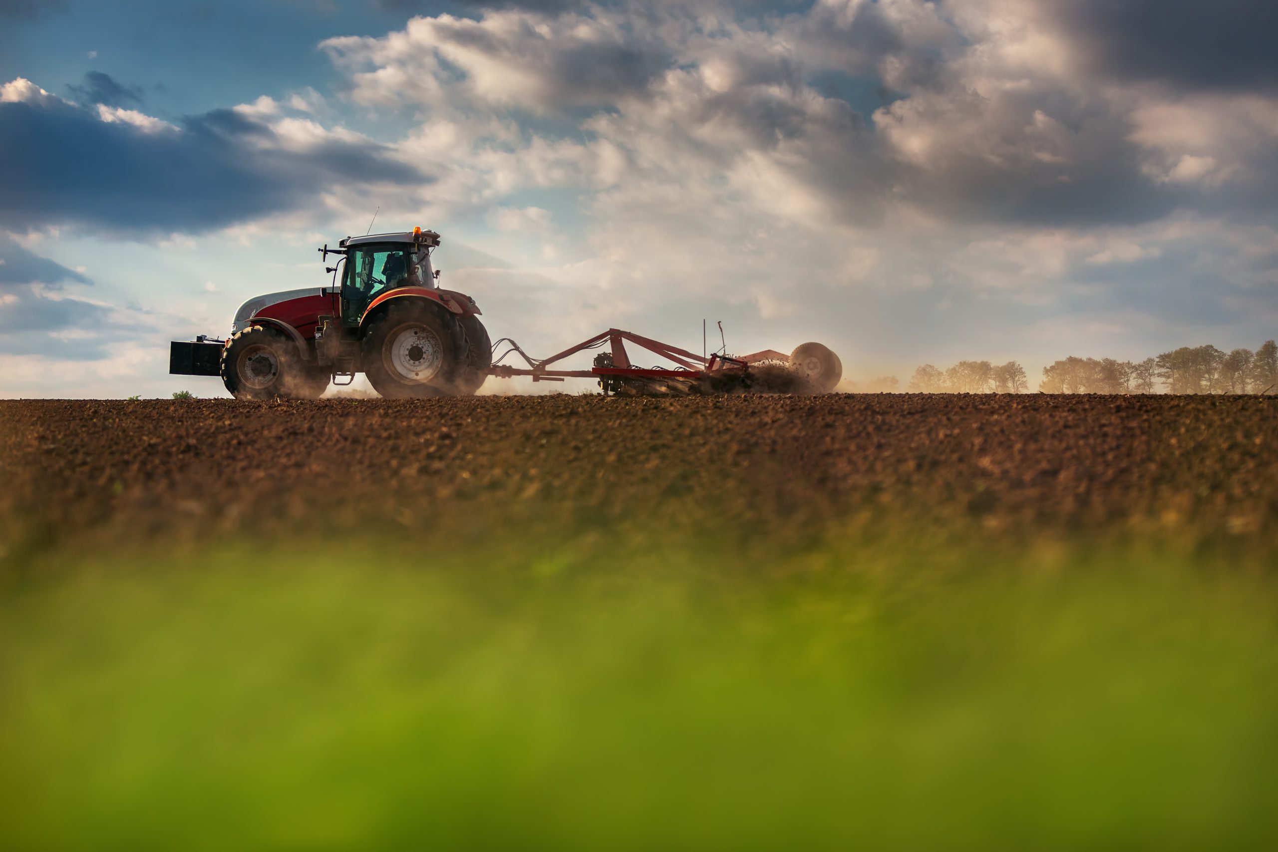 5 days for good, Supporting Food Security in Canada, image of a tractor plowing a field in Canada, beautiful sky and green in the foreground