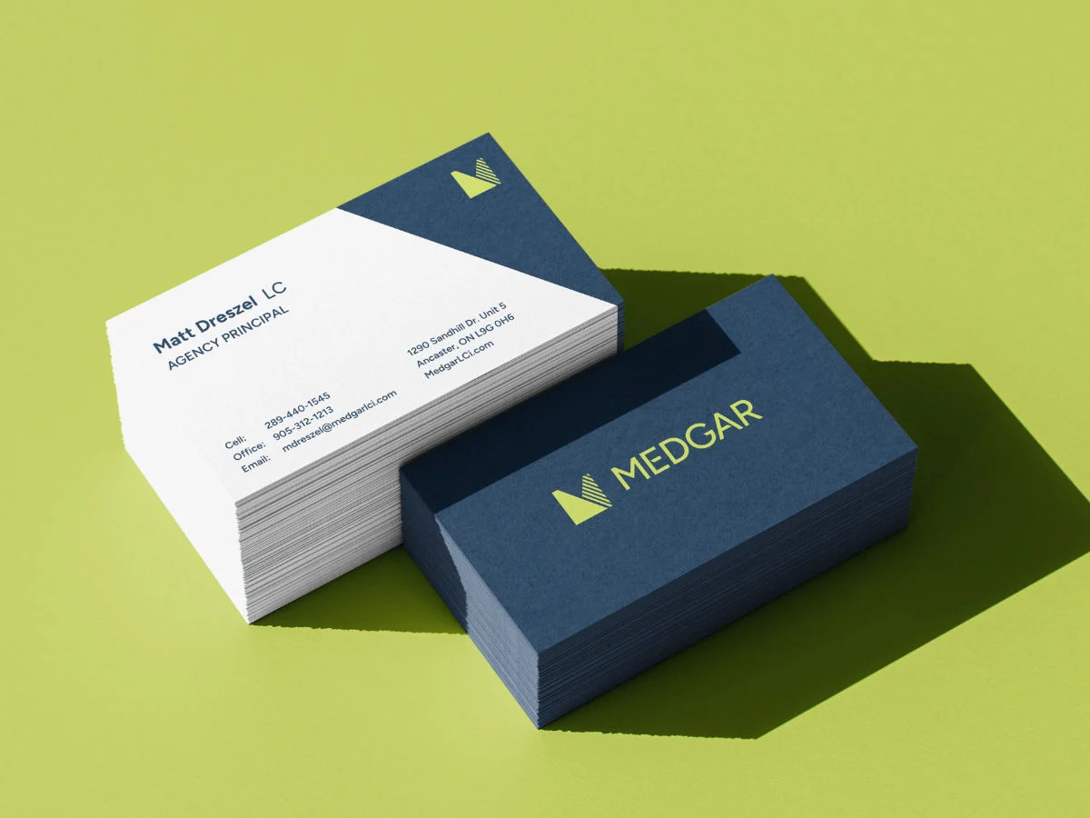 Sample mockup of Medgar's business cards on a green backdrop.